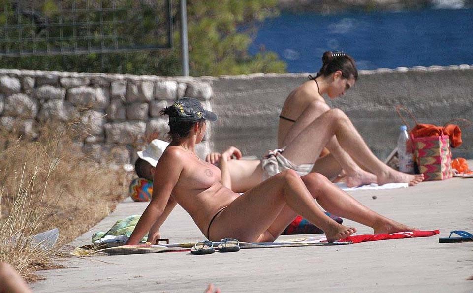 Jeune mince aux seins volumineux nue sur une plage nudiste
 #72250434