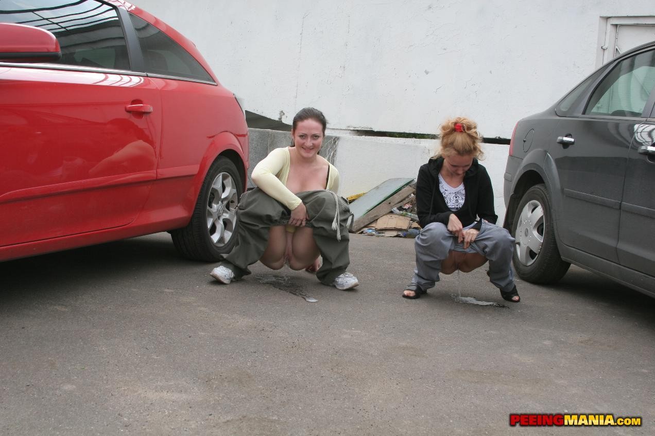 A couple of nasty squatted gals empty their bladders among the cars #76562317