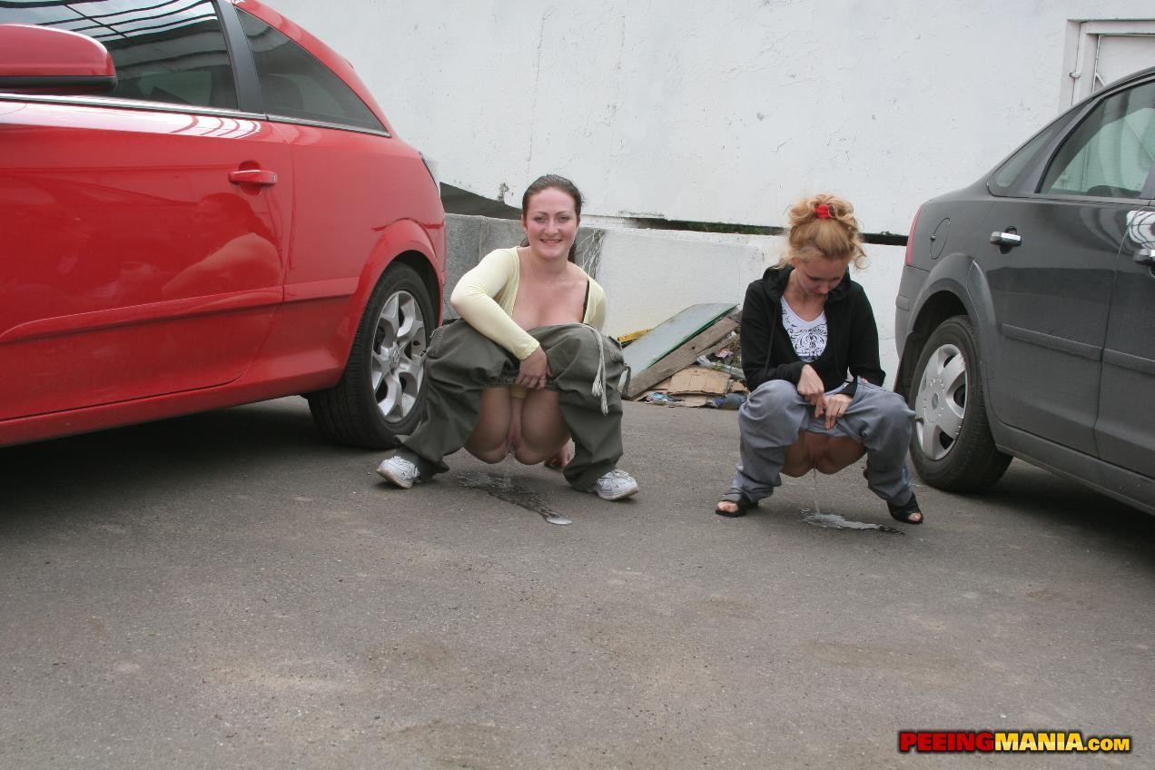 A couple of nasty squatted gals empty their bladders among the cars #76562322