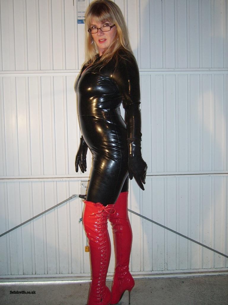 Fetisch Ehefrau trägt engen Latex Catsuit und rote Heeld Stiefel
 #73763484