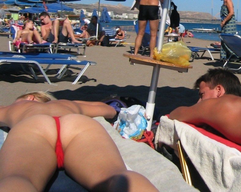 ヌーディストの女の子がビーチで寝そべっています。
 #72255697