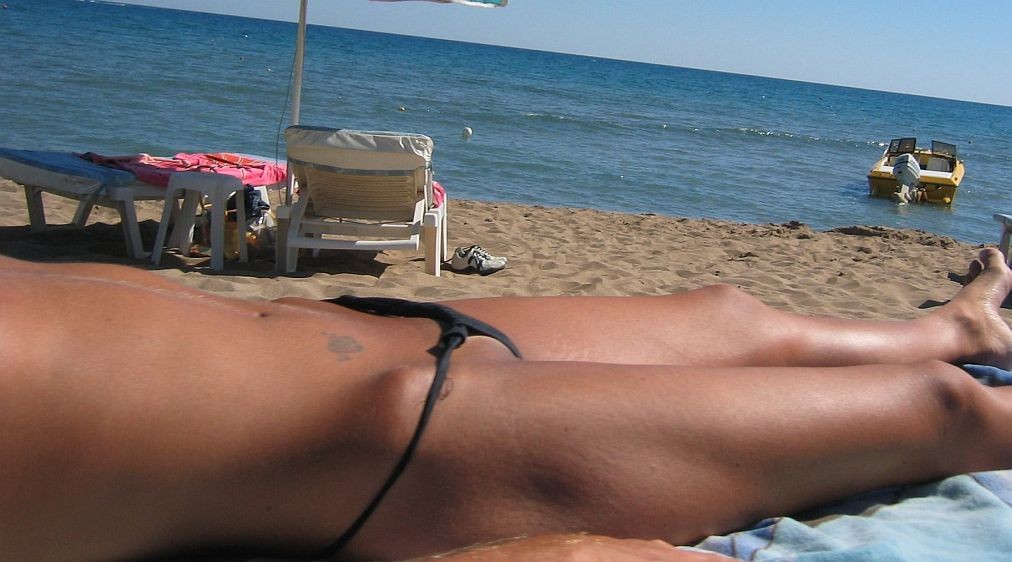 Regardez cette fille nudiste s'allonger sur la plage publique.
 #72255704