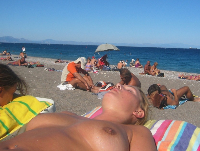 ヌーディストの女の子がビーチで寝そべっています。
 #72255717