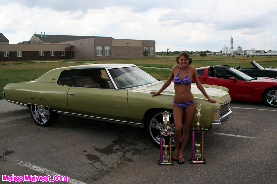Melissa midwest posando sobre coches en una feria de coches
 #67409937