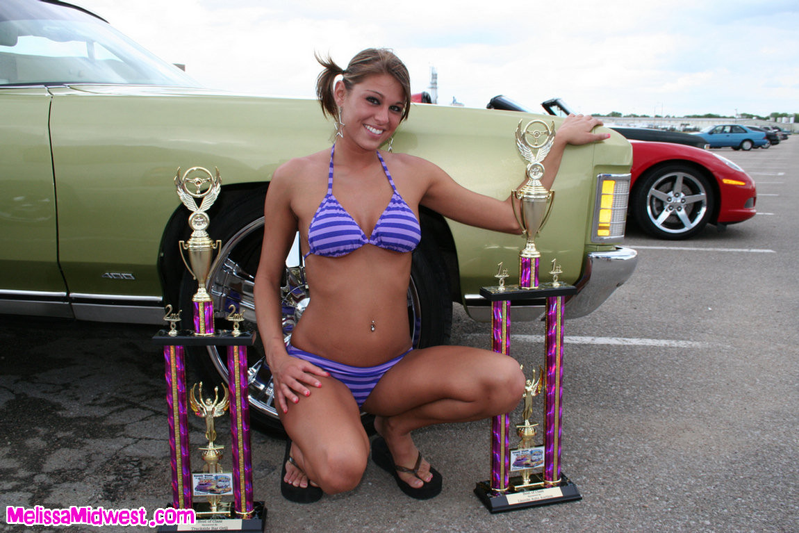 Melissa midwest posando sobre coches en una feria de coches
 #67409999