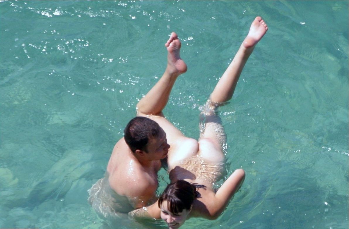 Una hermosa morena nudista juega en el agua
 #72252694