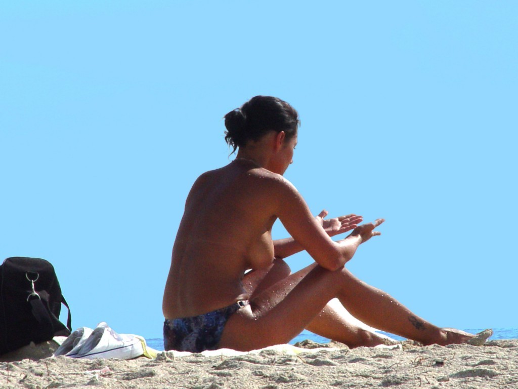 Una hermosa morena nudista juega en el agua
 #72252741