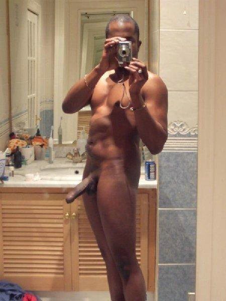 Un homme noir se filme devant un miroir.
 #76946198