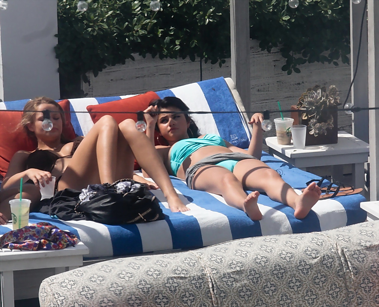 Selena gomez montrant son pied de biche et ses gros seins dans un bikini bleu clair à la piscine. 
 #75252467