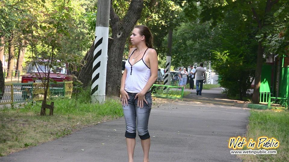 Une fille qui a un besoin désespéré de pisser mouille son jean, ses pieds et l'asphalte.
 #73239061