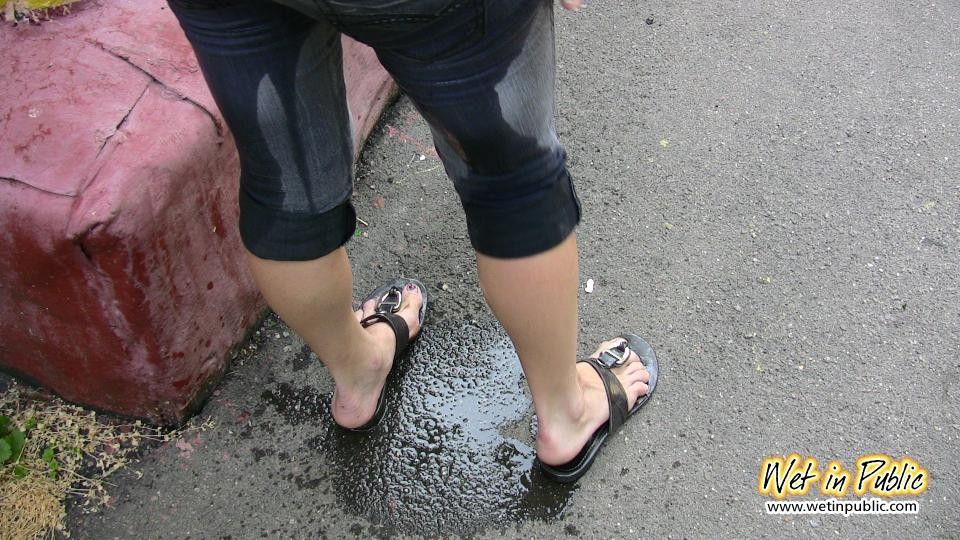 Pulcino in disperato bisogno di pisciare si bagna i jeans, i piedi e l'asfalto
 #73239075