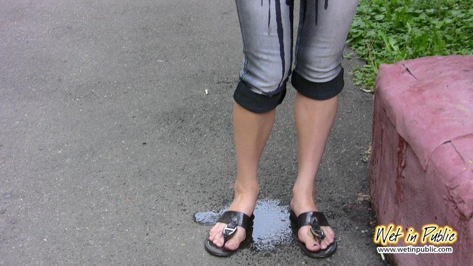 Pulcino in disperato bisogno di pisciare si bagna i jeans, i piedi e l'asfalto
 #73239084