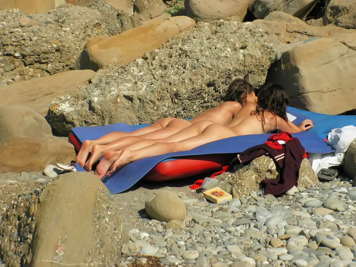 Giovani nudi giocano insieme in una spiaggia pubblica
 #67092244