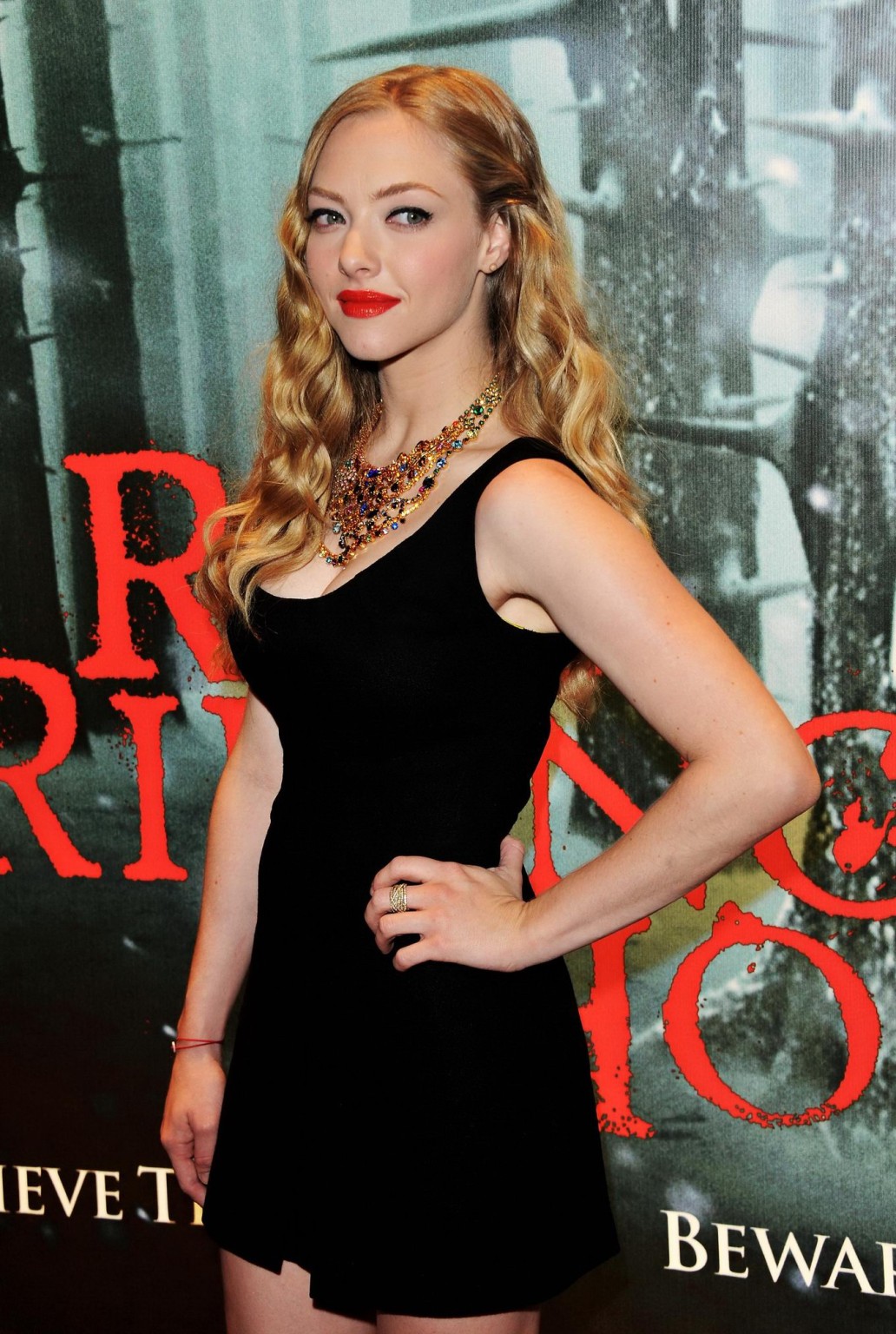 Amanda seyfried portant une petite robe noire à l'écran du "chaperon rouge" avec de belles jambes
 #75309578