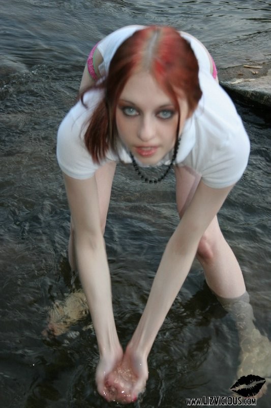 Une jeune gothique coquine se déshabille et se mouille dans le ruisseau.
 #70626534