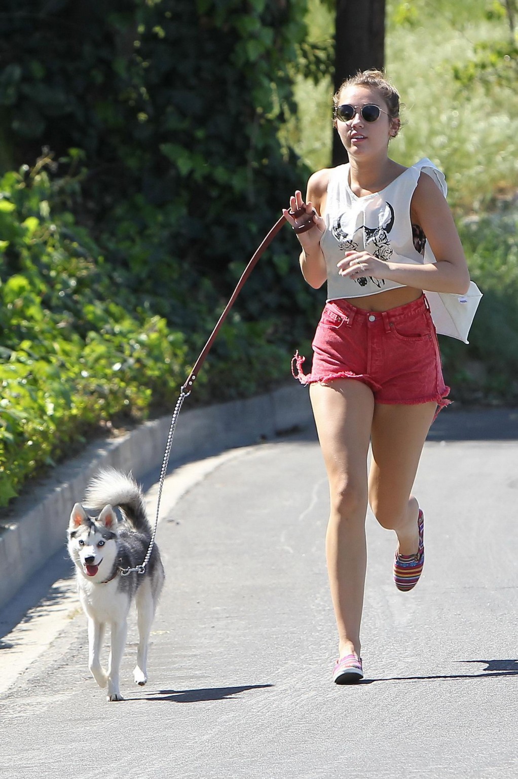 Miley Cyrusが赤いホットパンツを履いて犬のように走る姿
 #75271538