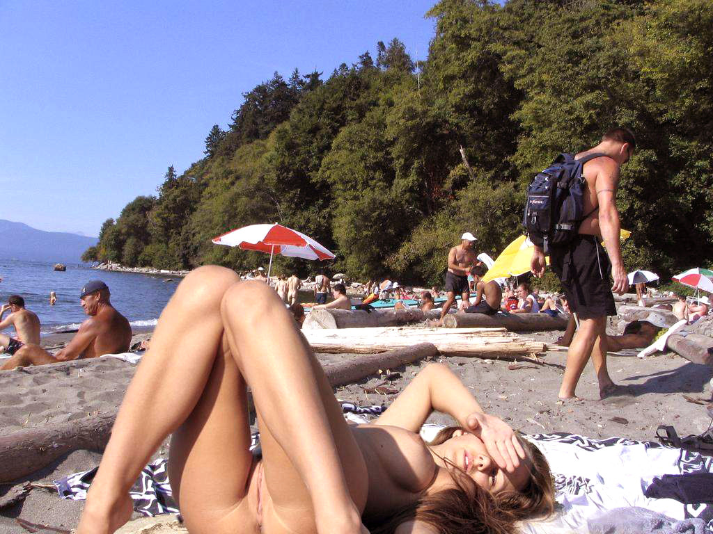 Giovani nudisti si spogliano e riscaldano una spiaggia pubblica
 #72250866