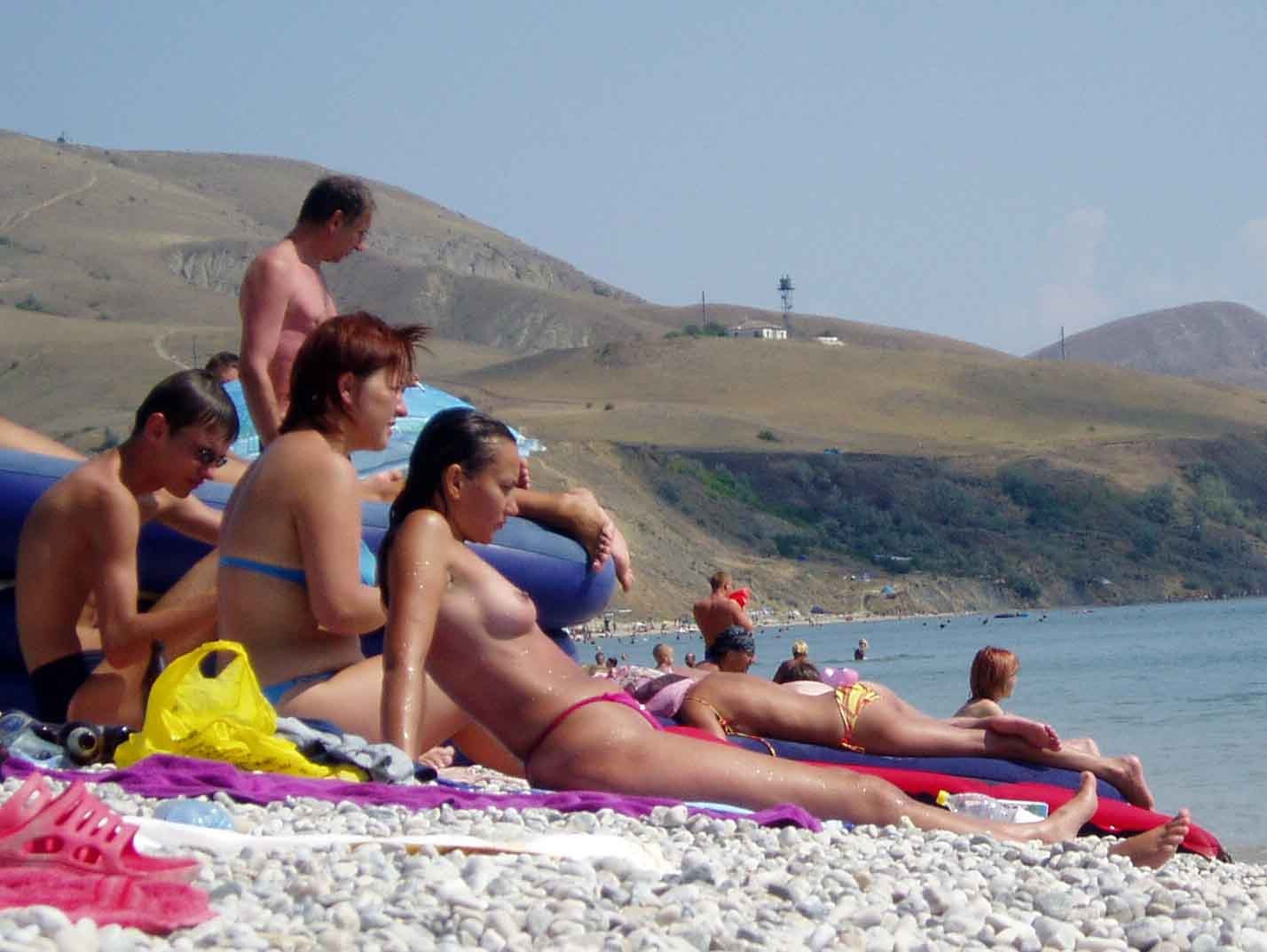 Une jeune femme aux seins volumineux exhibe son corps nu sur la plage.
 #72251146