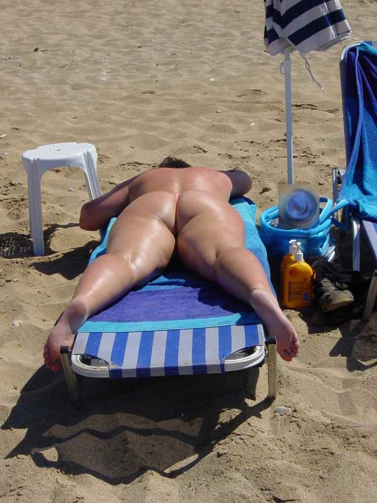 Une jeune femme aux seins volumineux exhibe son corps nu sur la plage.
 #72251233