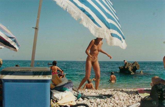 Una ragazza nudista a malapena legale si illumina sulla spiaggia
 #72251731