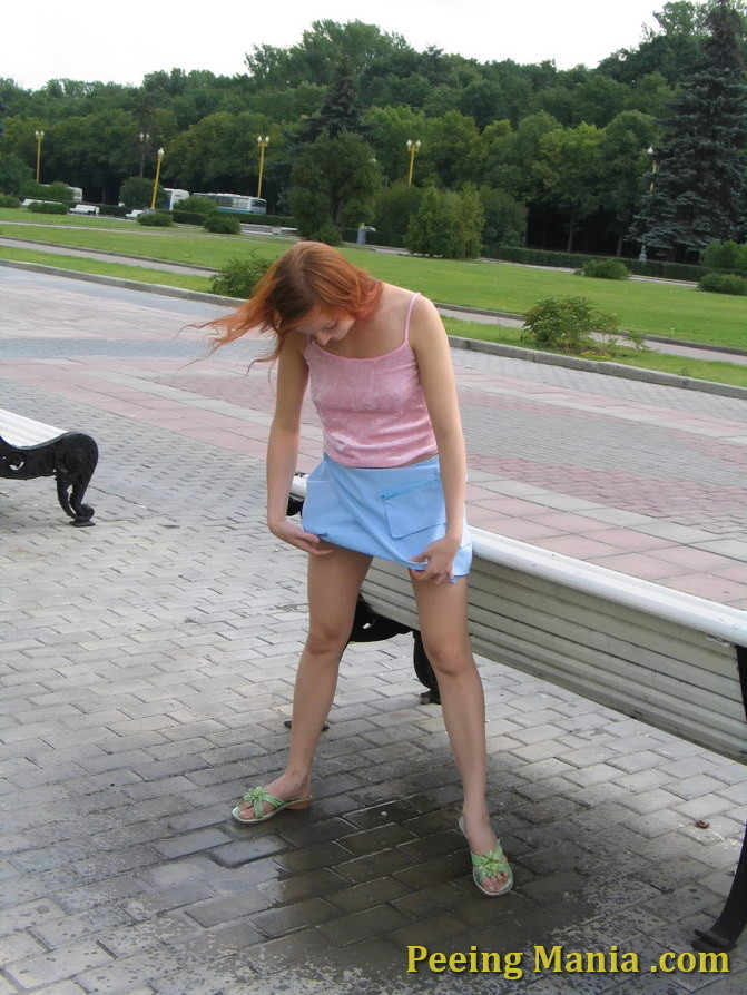 Une jeune fille enjouée vide sa vessie assise sur un banc dans un parc.
 #76568727