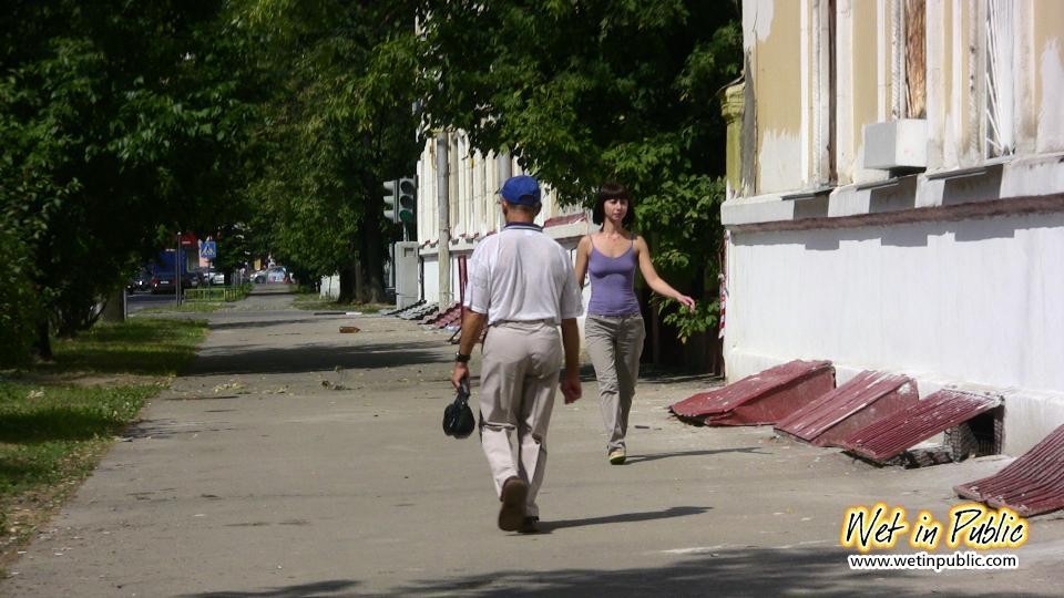 Une nana amateur se tient sur un trottoir et pisse sans vergogne dans son pantalon.
 #73239813