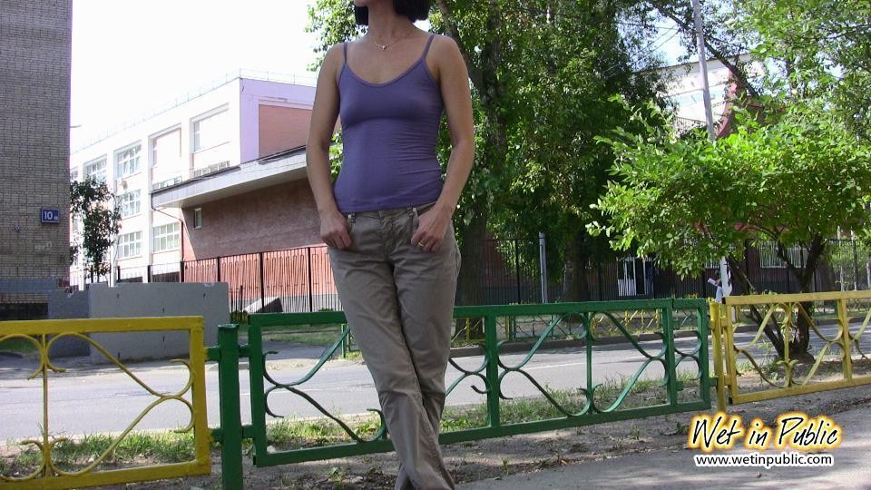 Amateur chick standing on a sidewalk and shamelessly pissing her pants #73239831