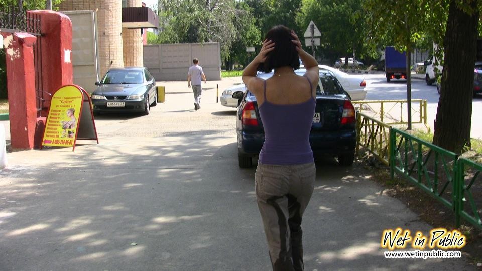 Amateur chick standing on a sidewalk and shamelessly pissing her pants #73239852
