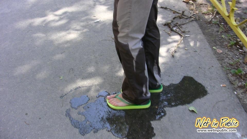 Amateur chick standing on a sidewalk and shamelessly pissing her pants #73239872