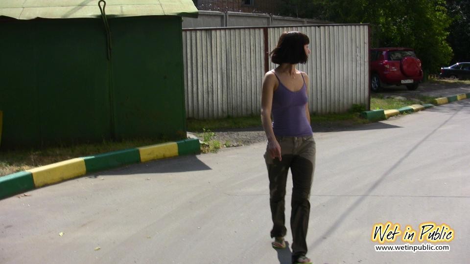 Amateur chick standing on a sidewalk and shamelessly pissing her pants #73239882