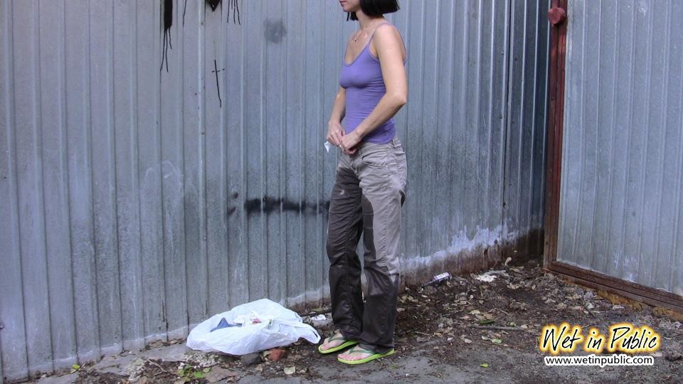 Amateur chick standing on a sidewalk and shamelessly pissing her pants #73239894