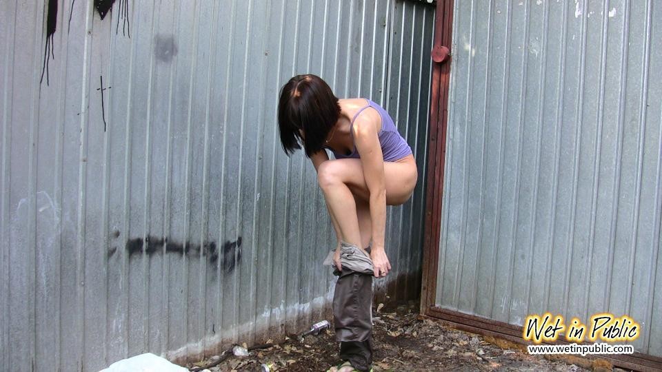 Amateur chick standing on a sidewalk and shamelessly pissing her pants #73239906