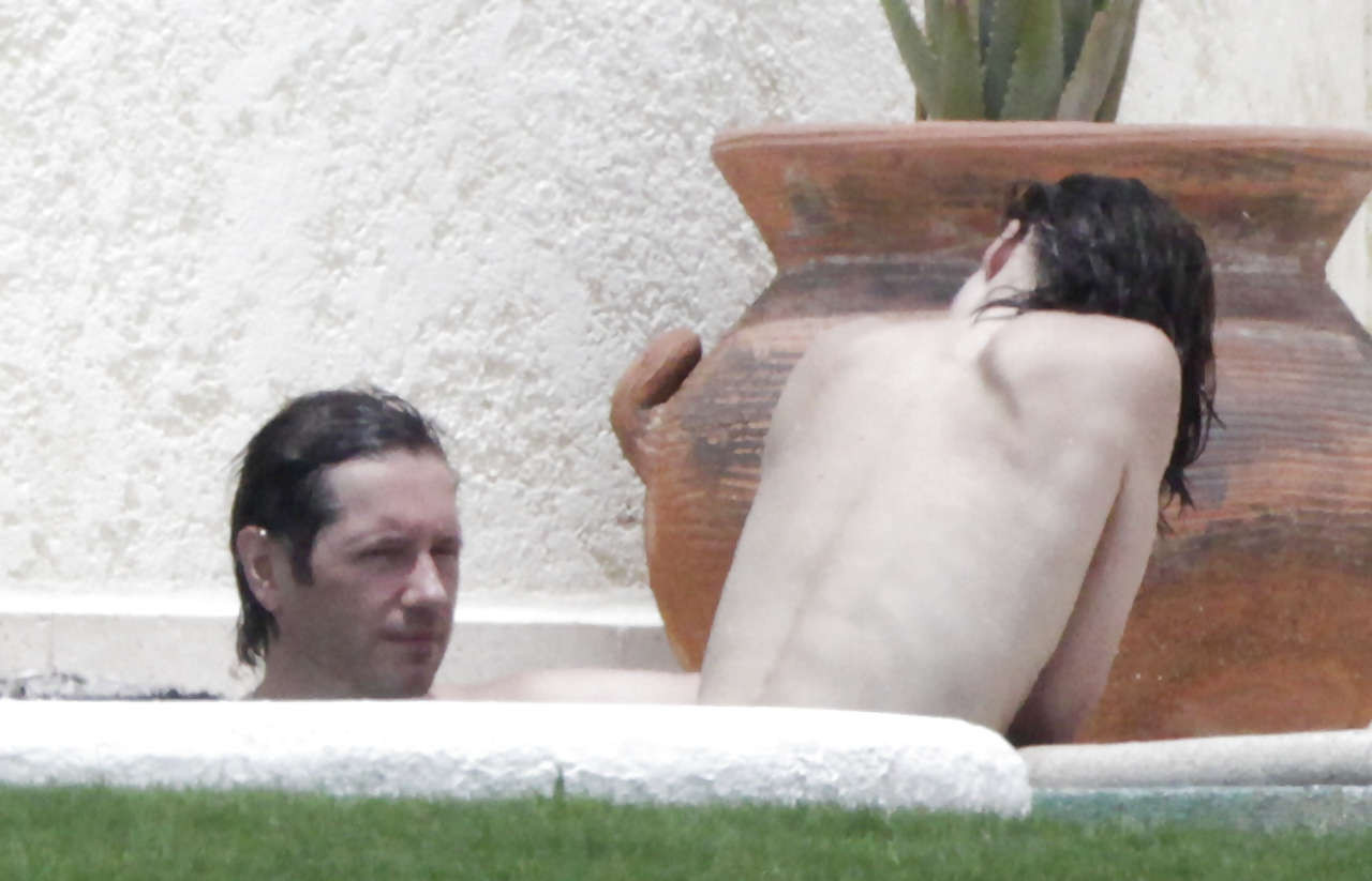 Milla Jovovich caught topless in pool by paparazzi and giving them middle finger #75289757