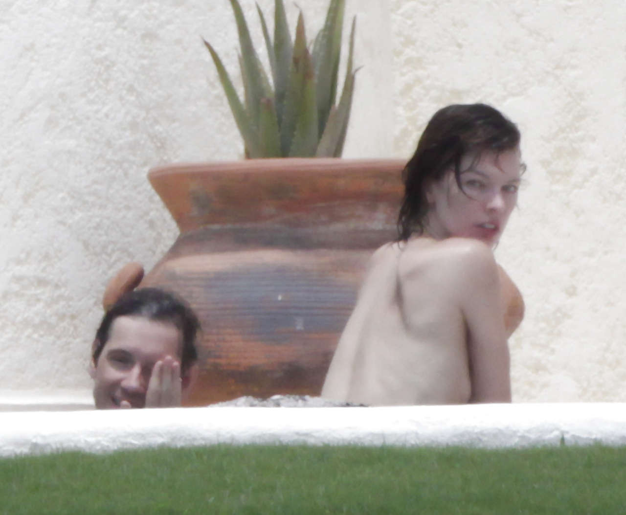 Milla Jovovich caught topless in pool by paparazzi and giving them middle finger #75289761