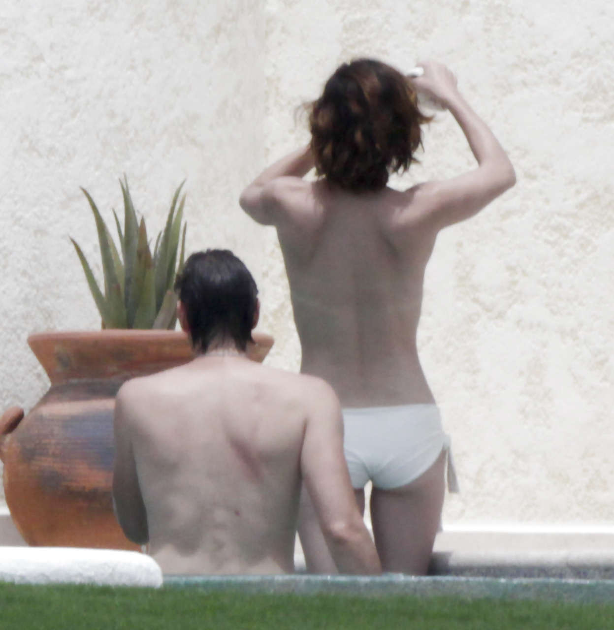 Milla Jovovich caught topless in pool by paparazzi and giving them middle finger #75289770