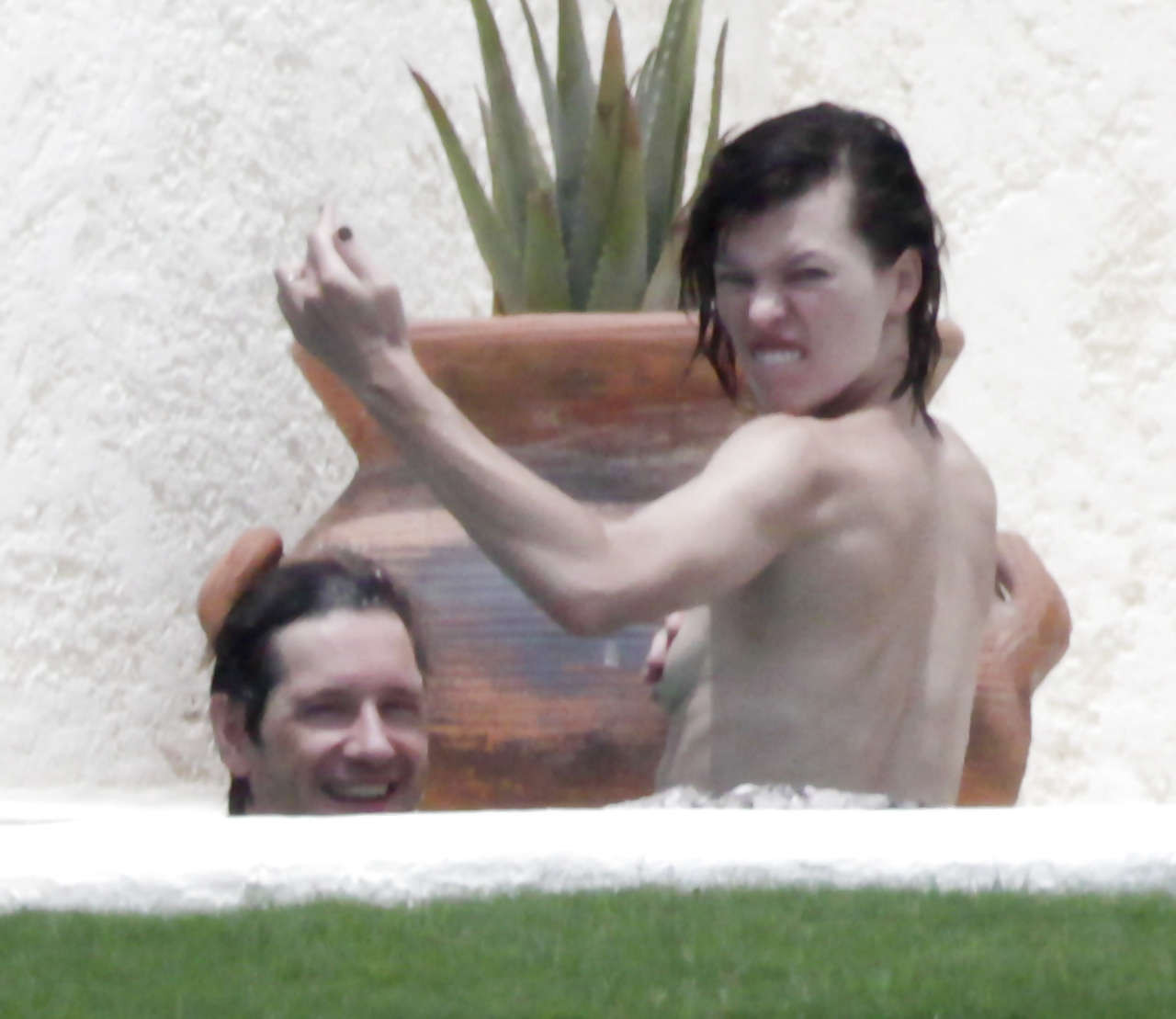 Milla Jovovich wird von Paparazzi oben ohne im Pool erwischt und zeigt ihnen den Mittelfinger
 #75289814