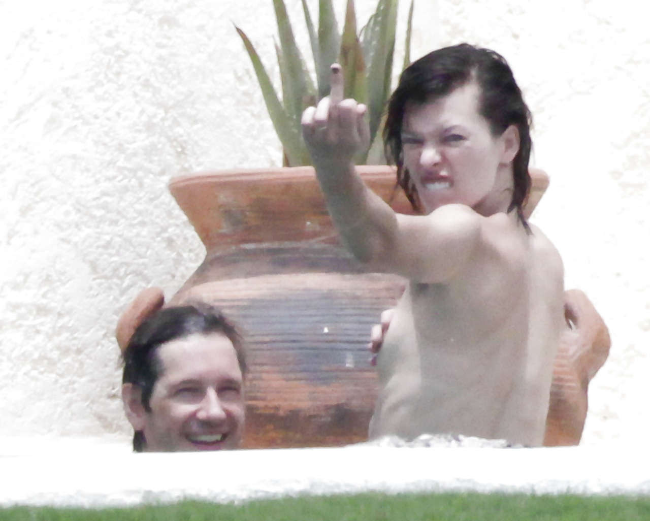 Milla jovovich surprise seins nus dans une piscine par des paparazzi et leur faisant un doigt d'honneur.
 #75289820
