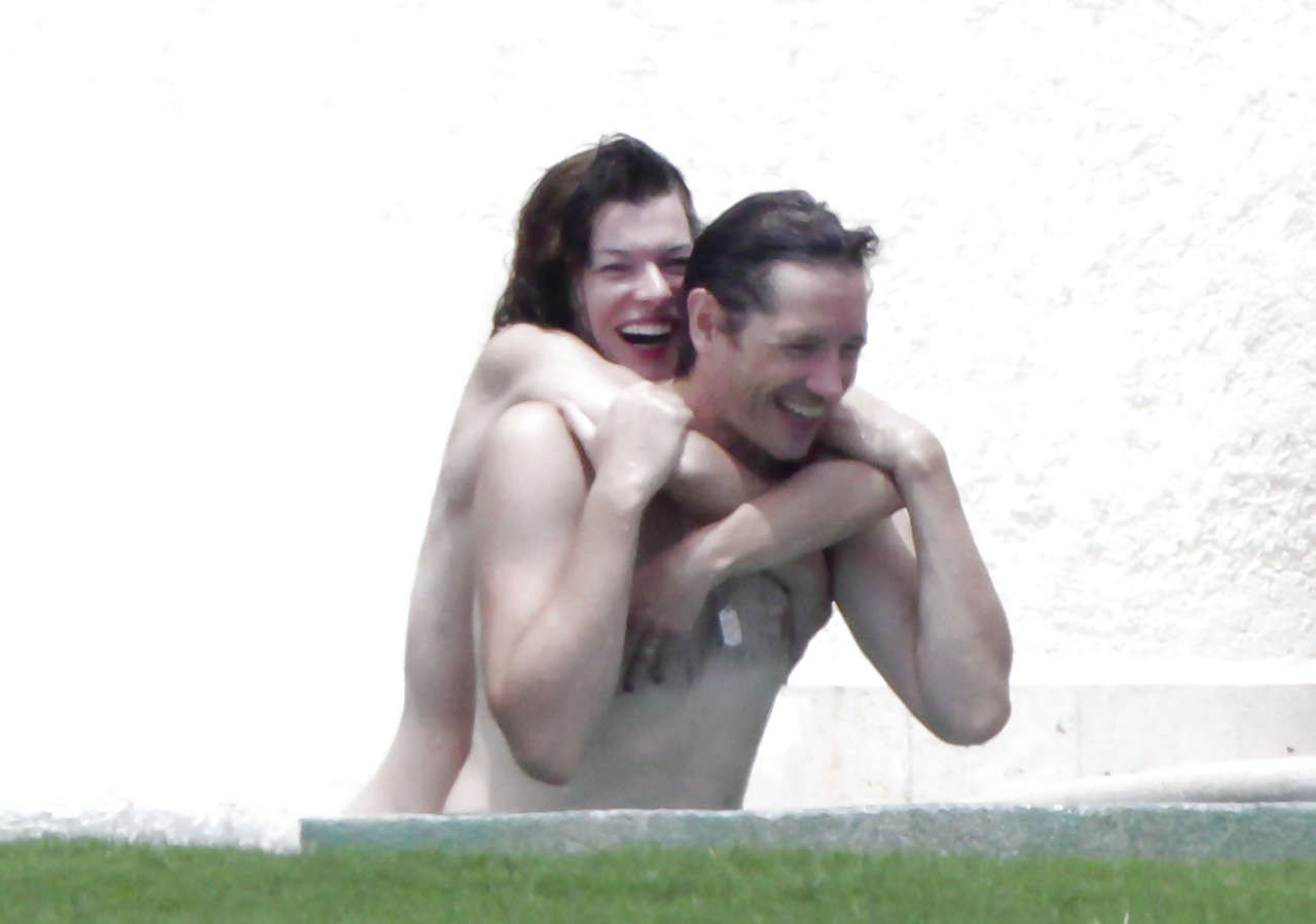 Milla Jovovich caught topless in pool by paparazzi and giving them middle finger #75289854