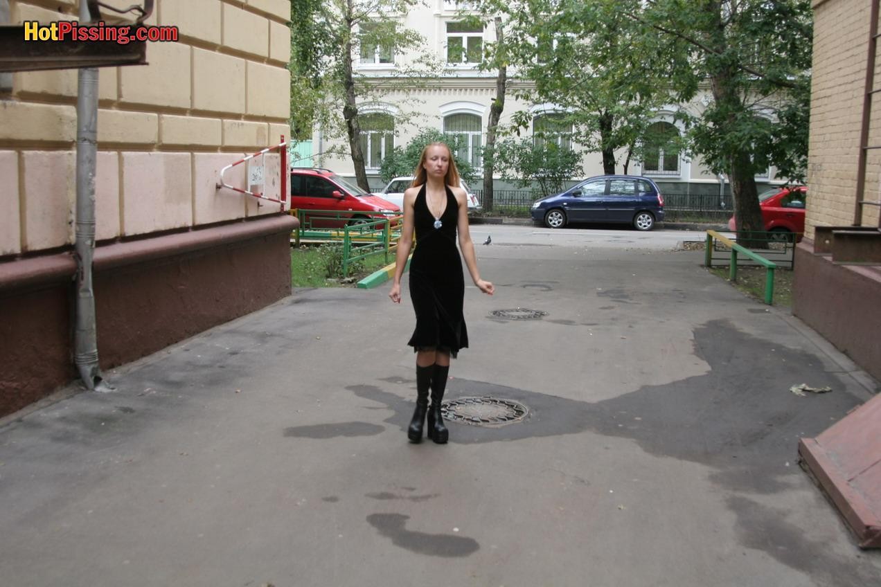 Gothic Lady in schwarzem Kleid und Plateaustiefeln pinkelt auf der Straße
 #76561214