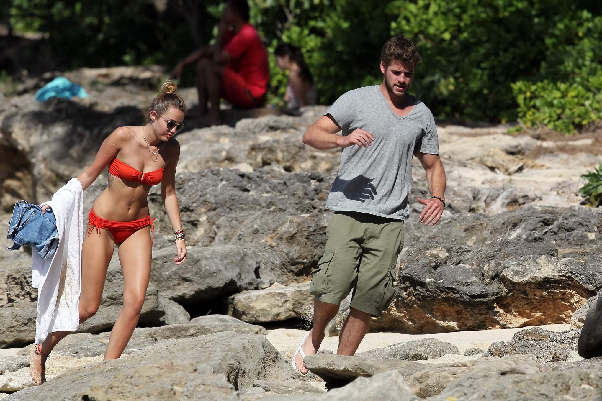 Miley cyrus luciendo un sexy bikini naranja en una playa de hawaii
 #75277793