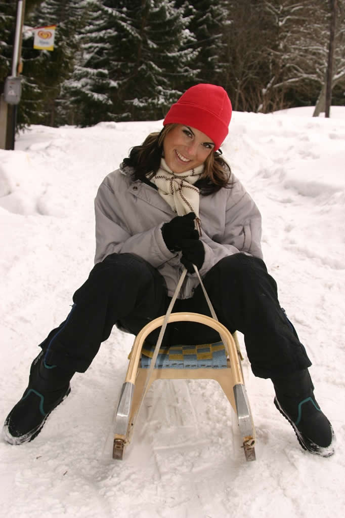 Jeune brune excitée se déshabillant en plein air sur une luge de neige
 #70668499