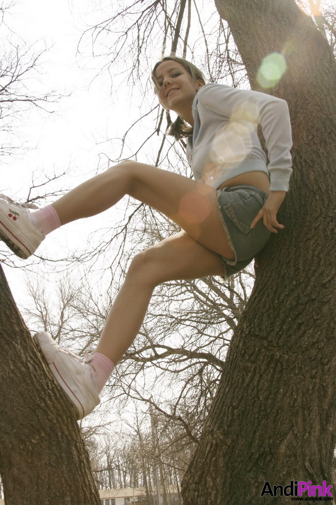 Linda chica joven trepando a un árbol al aire libre
 #67261904