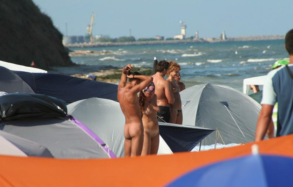 En la playa nudista las jóvenes juegan desnudas
 #72251708