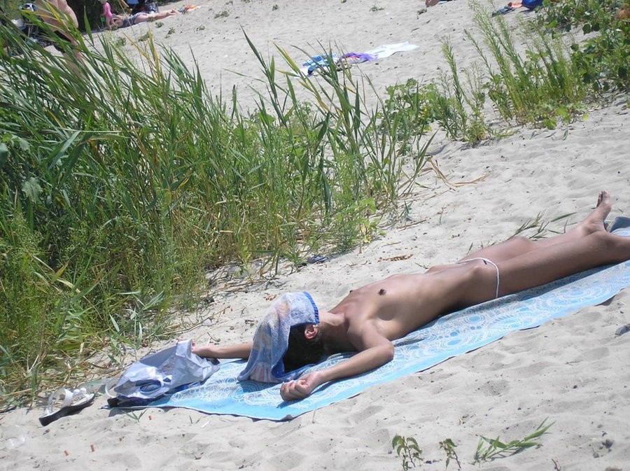 Des jeunes nudistes s'exposent sur une plage publique.
 #72247989
