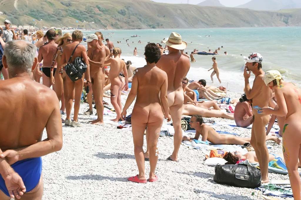 Jóvenes sexy juegan juntos en una playa pública #70298440
