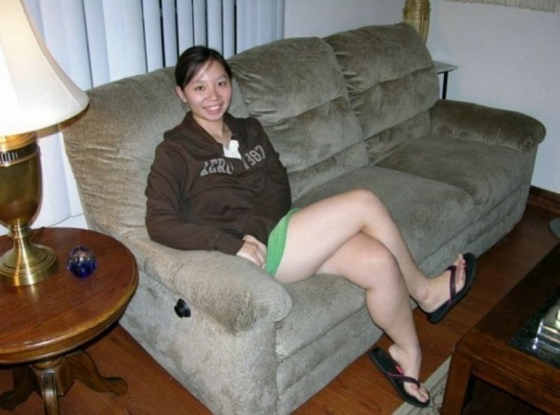 Une jeune asiatique entièrement nue dans un canapé montre ses seins serrés.
 #69875193