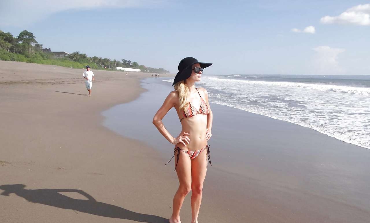 Paris Hilton in bikini striminzito e cappello nero sulla spiaggia foto dei paparazzi
 #75282019