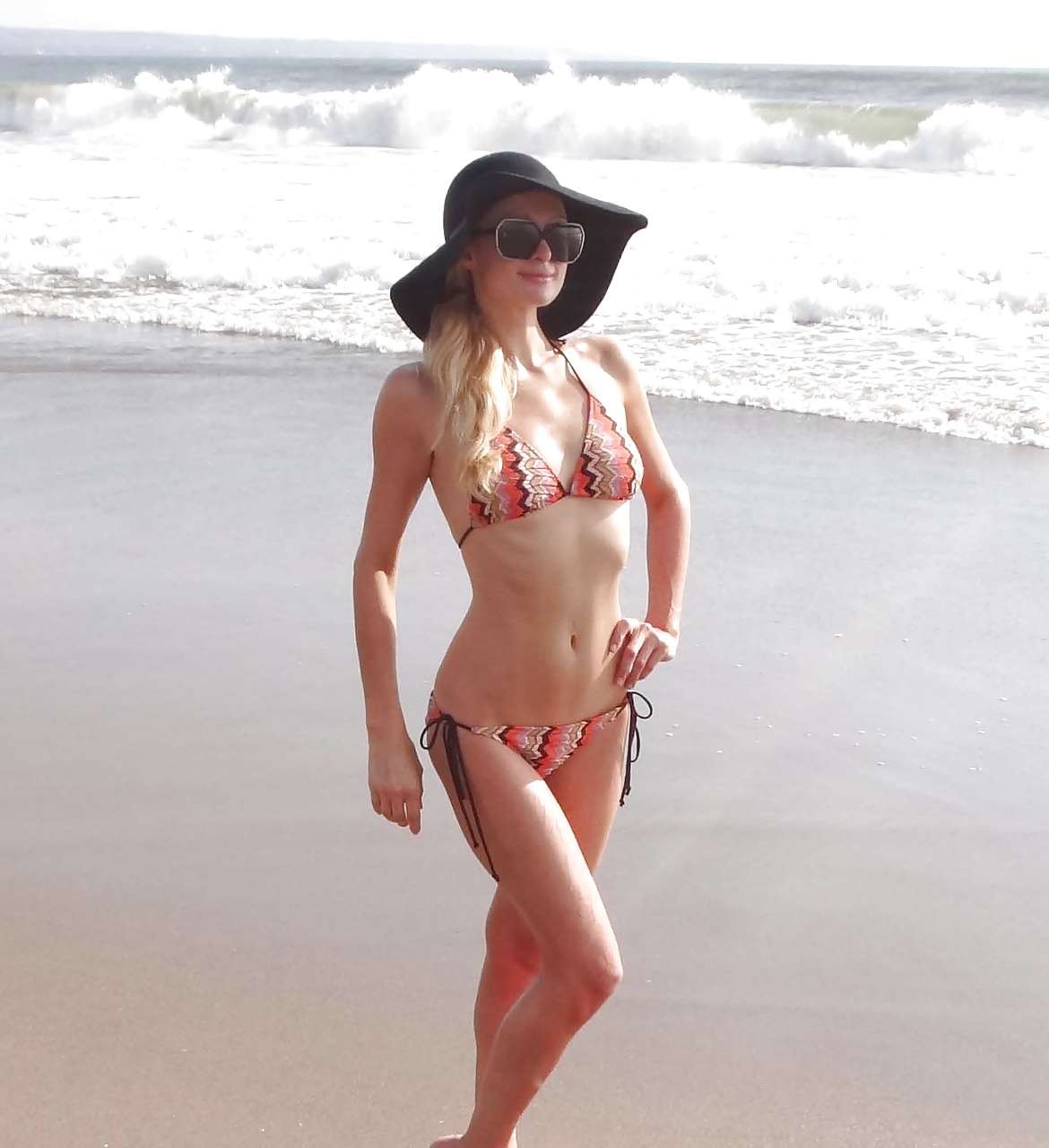 Paris Hilton in bikini striminzito e cappello nero sulla spiaggia foto dei paparazzi
 #75282028