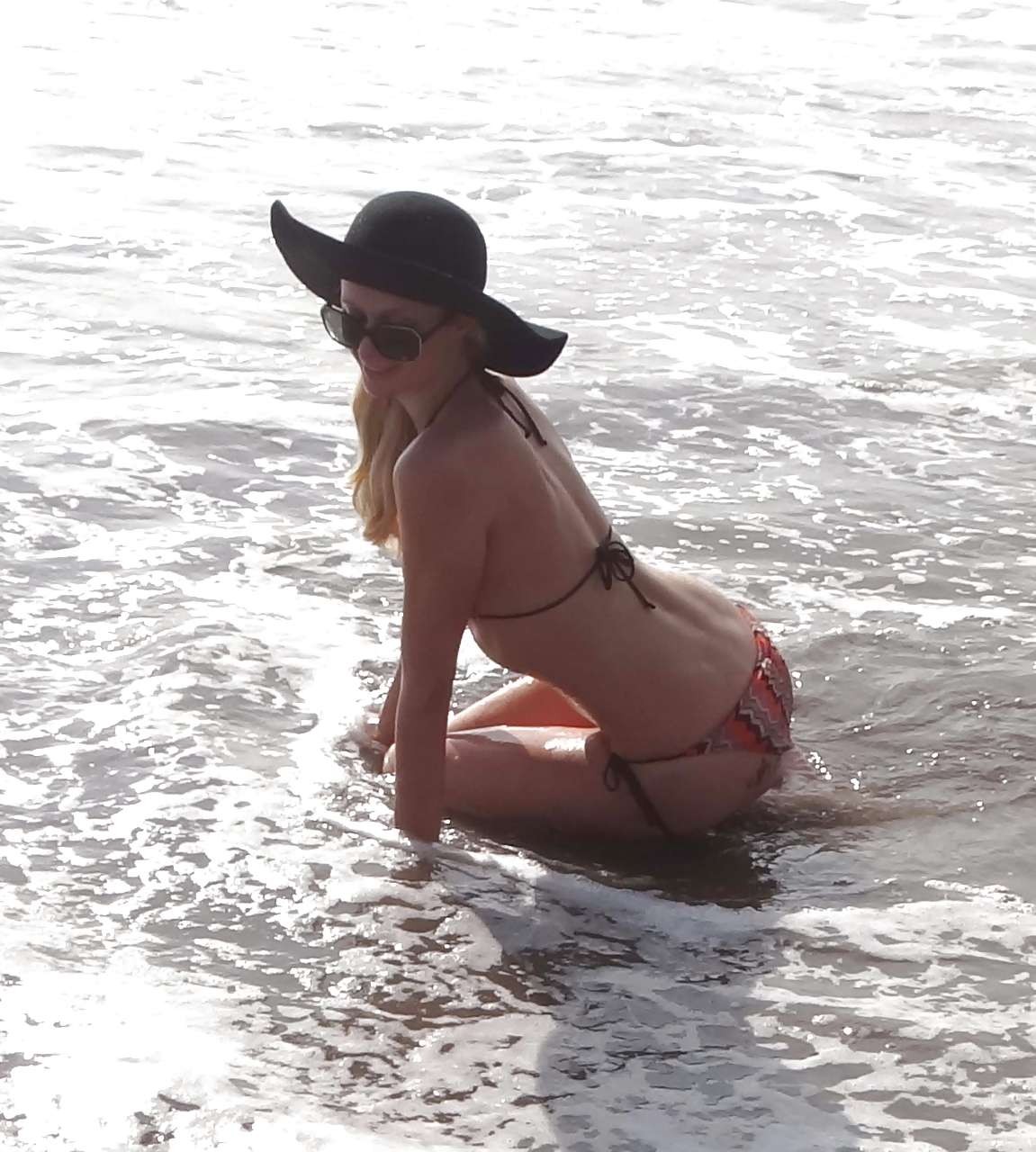 Paris Hilton in bikini striminzito e cappello nero sulla spiaggia foto dei paparazzi
 #75282049