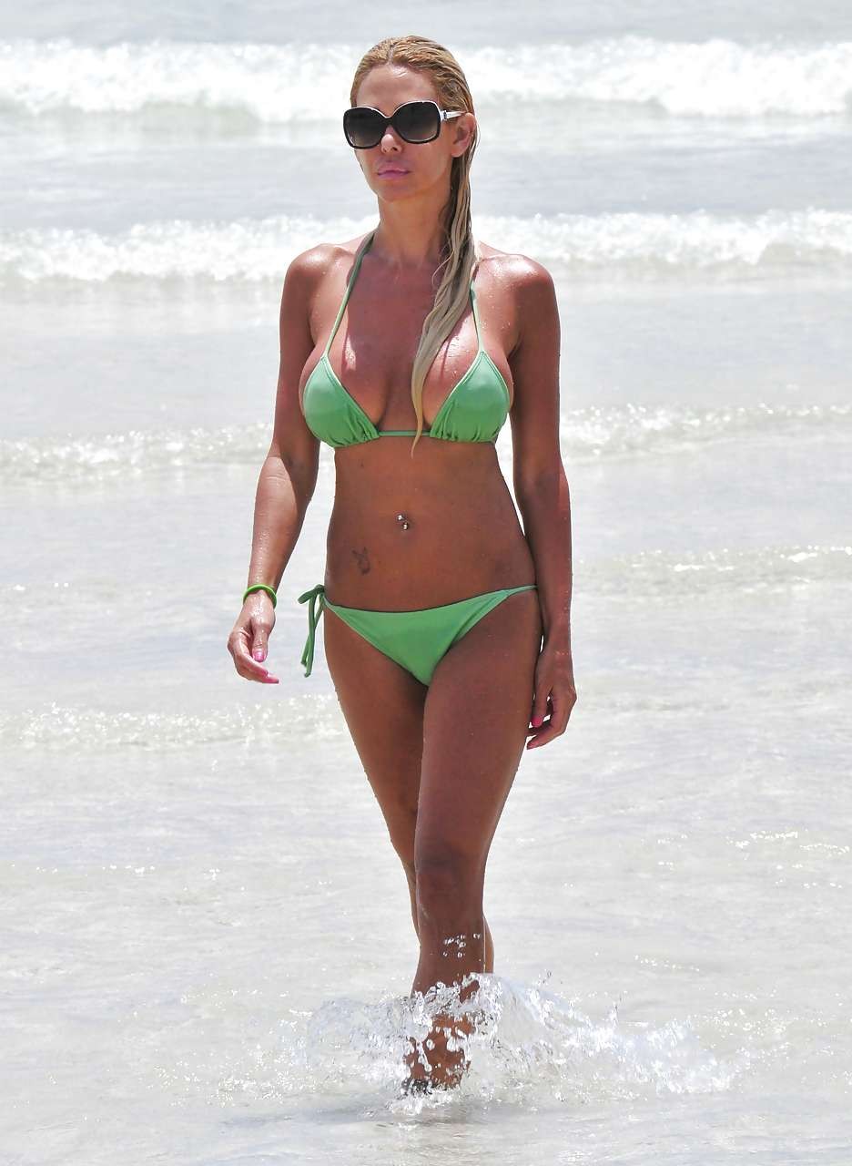 Shauna sand montrant ses superbes fesses dans un minuscule bikini vert sur la plage.
 #75296368